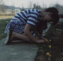Sarah pretending to play with flowers